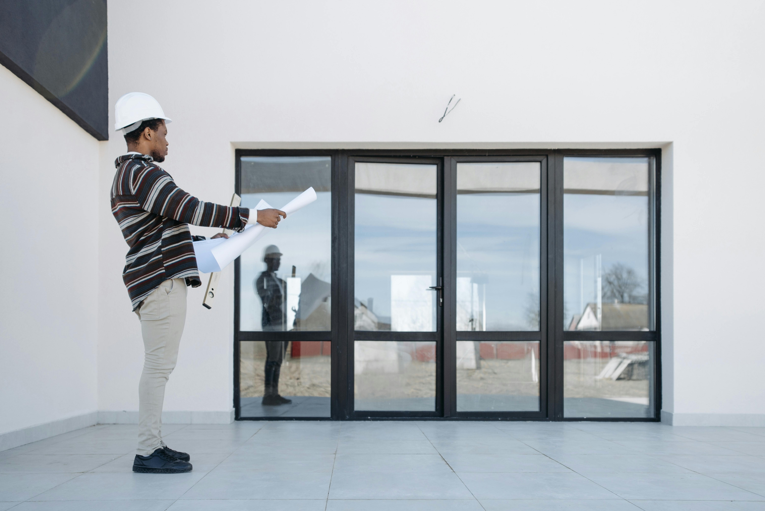Man looking at plans by glass doors